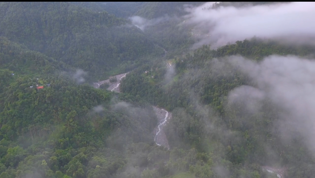 Waterfall visible in the distant green valley